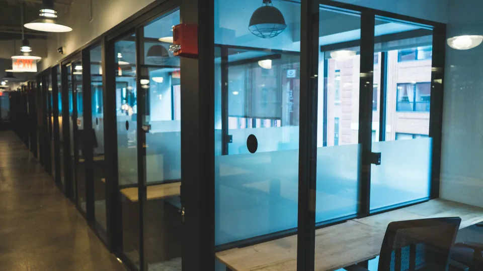 A row of glass-partitioned offices along an interior corridor