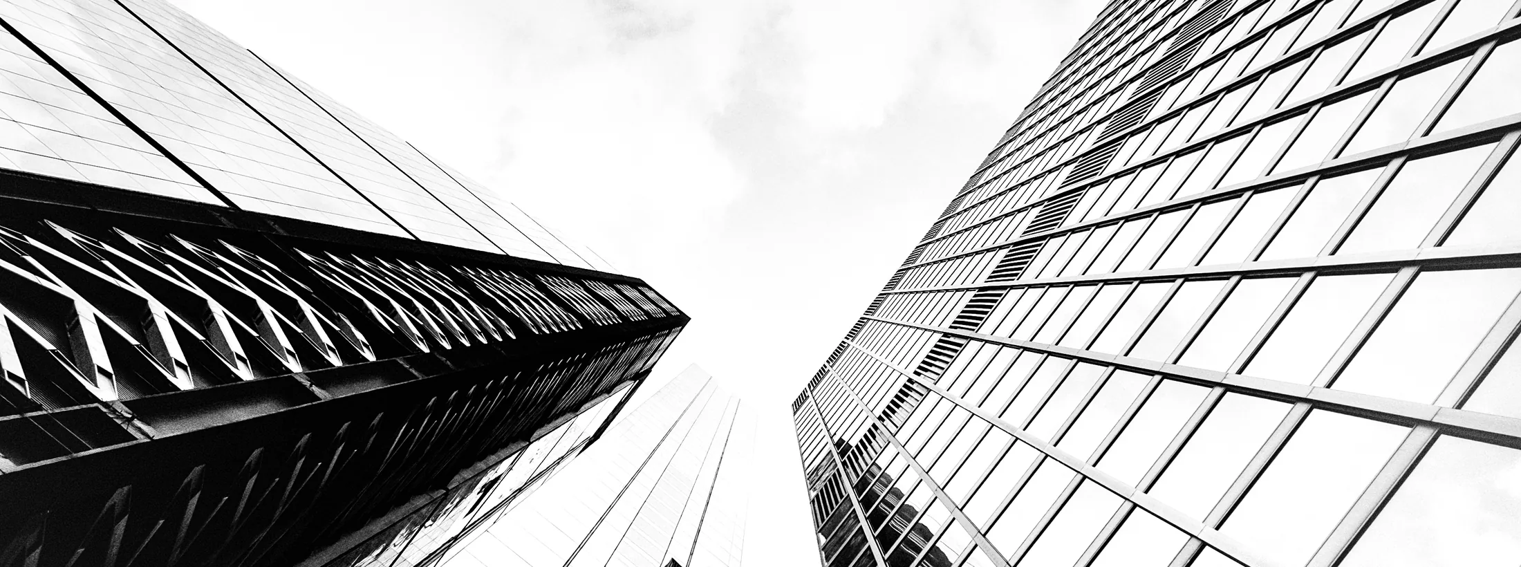 Glass office towers seen from street level, looking up